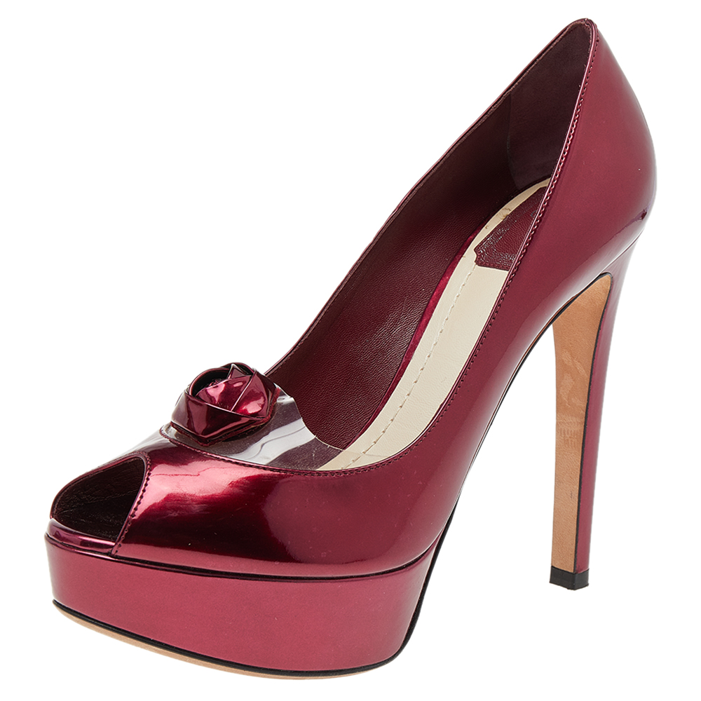 This pair of stunning pumps by Dior is the epitome of sophistication. They come made from patent leather in a burgundy shade are designed with flower detail on the peep toe vamps and have 13 cm heels. This pair of pumps is sure to adorn you with high fashion.