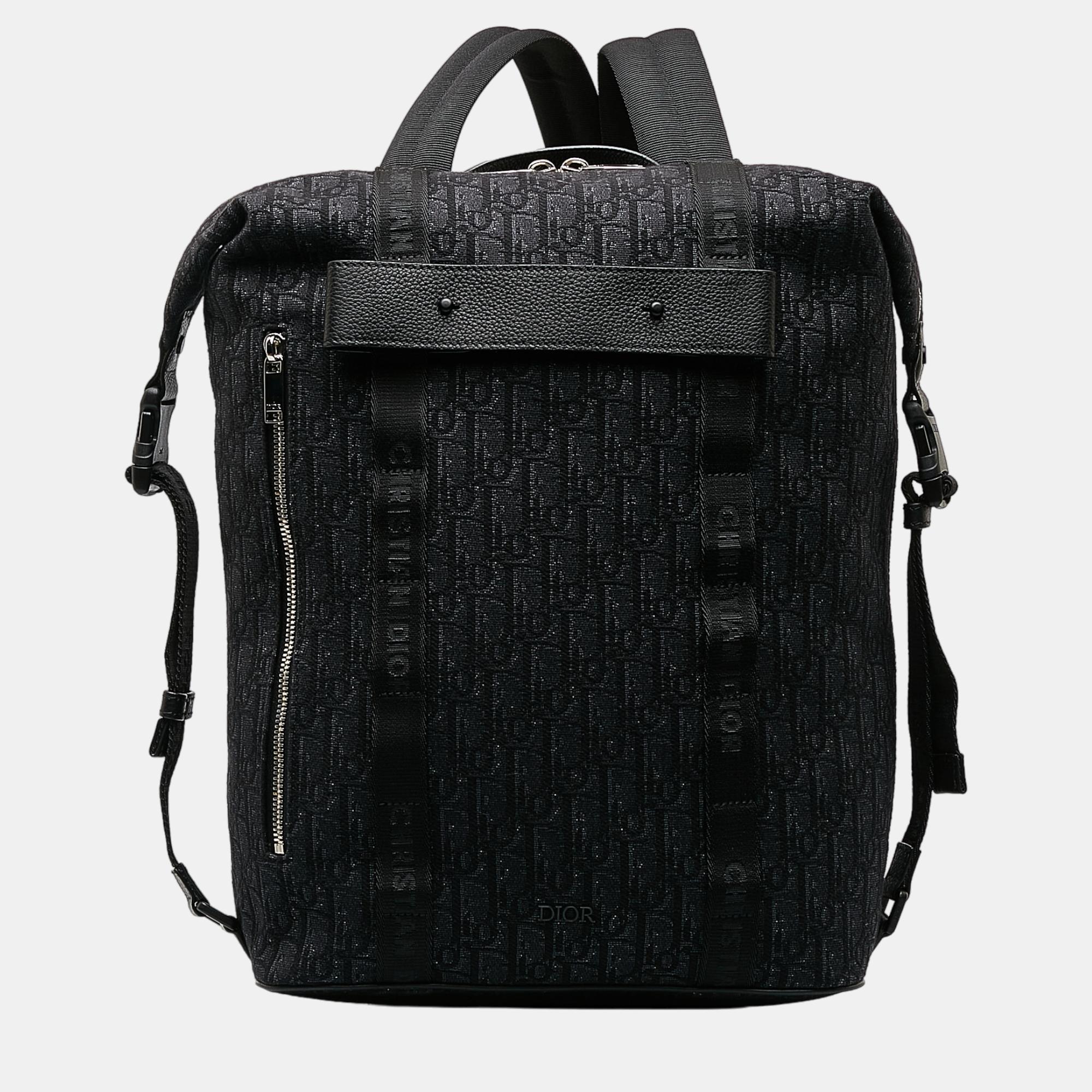 This backpack features a canvas body a flat top handle flat back straps a top zip closure front and back zip pockets and an interior slip pocket
