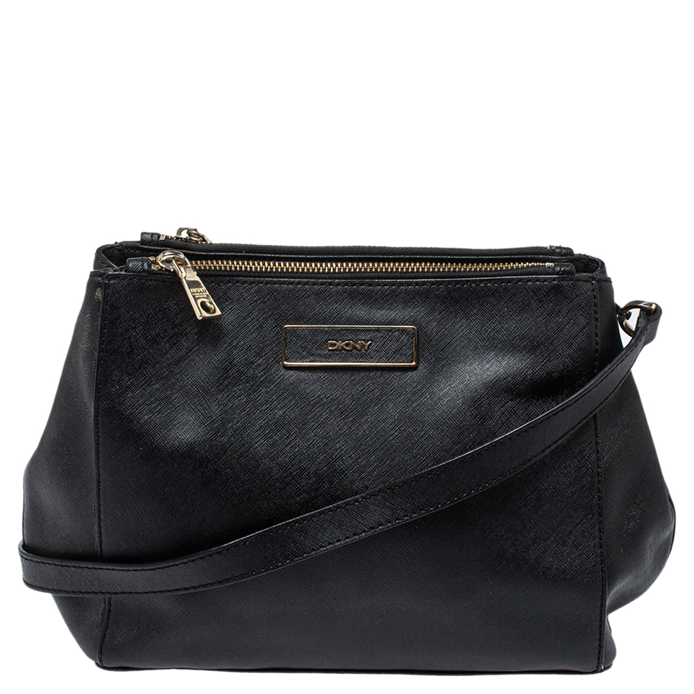 This Dkny bag is stylish and practical a creation every fashionista must own Crafted from fine leather in a black shade it comes with dual zip closures that open to a spacious fabric lined interior to hold your essentials. It can be carried with both formal and casual attires.
