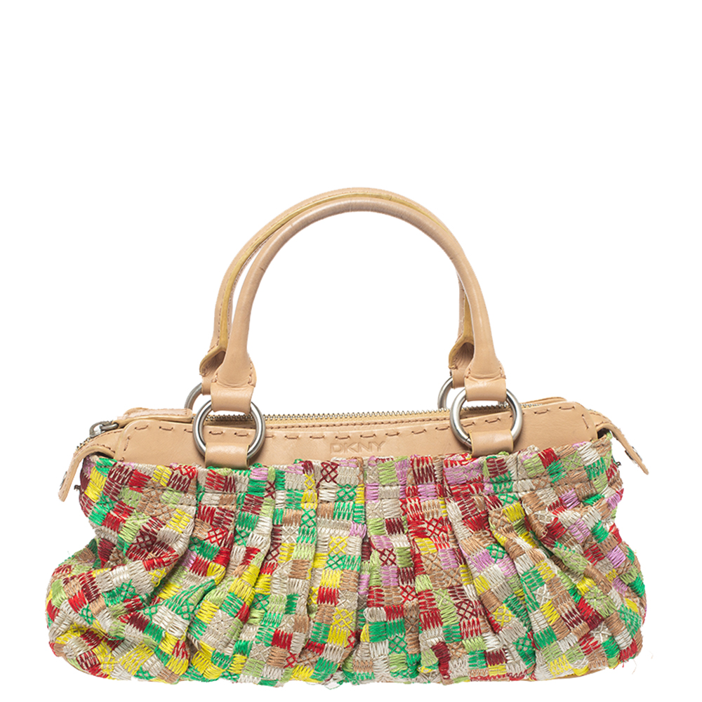 Incorporate some sophistication into your look by carrying this beautiful handbag from the house of Dkny It has been crafted from embroidered canvas and comes in multicolored hues. It has dual handles zip closure and silver tone hardware. It opens to a fabric lined interior with enough space for essentials.