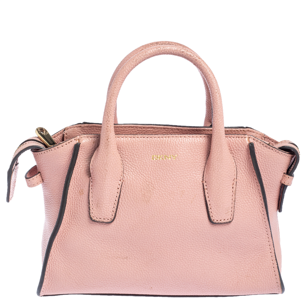 This Chelsea satchel from DKNY offers style and sheer practicality. Its a versatile piece crafted with leather it comes in a subtle shade of pink. It features dual handles a detachable shoulder strap a nylon interior and gold tone hardware.