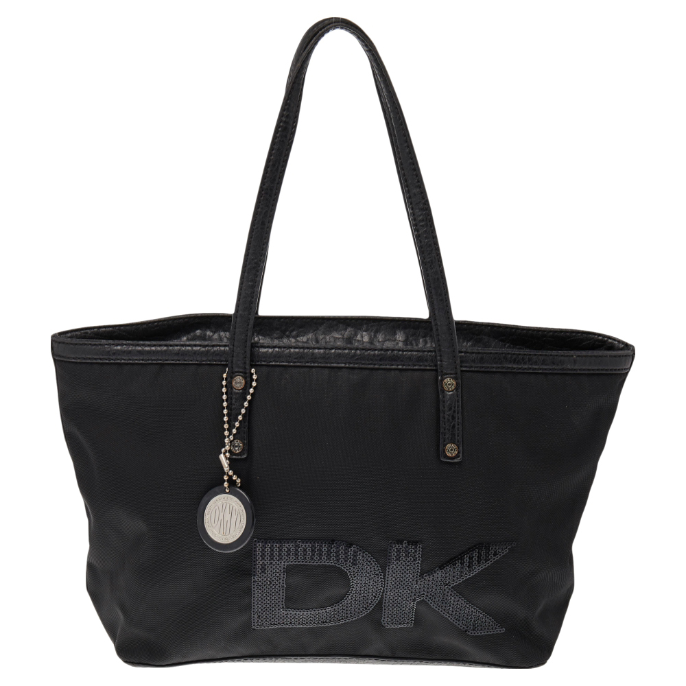 This beautifully stitched tote in nylon and leather is by DKNY. With a capacious satin lined interior it will house more than your essentials. Boasting two handles the brand logo on the exterior and a fine finish this black tote offers style and everyday practicality.