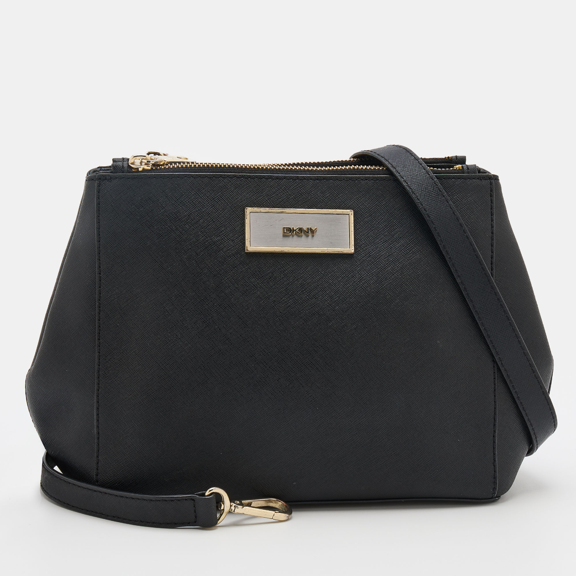 This DKNY bag perfectly combines fashion and function. Made from black leather it displays a shoulder strap a brand signature on the front and gold tone hardware. The spacious fabric lined interior makes it an ideal accessory for everyday use.