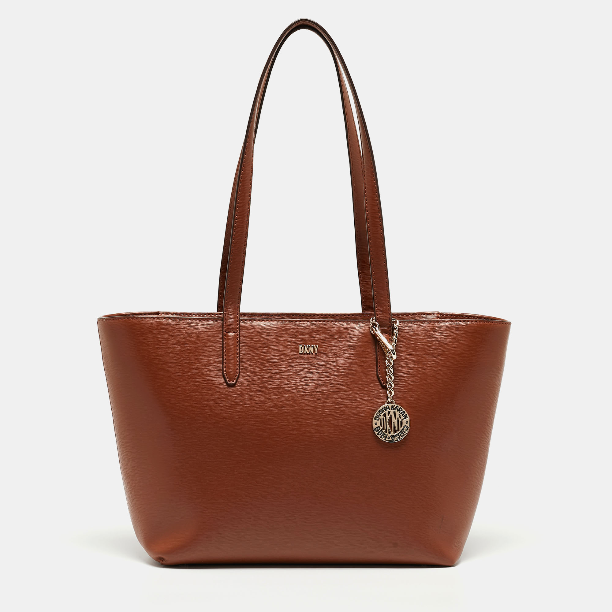 Bringing a mix of timeless fashion and fine craftsmanship is this tote. The bag comes with a durable exterior comfortable handles shiny hardware and a capacious interior. Fine elements complete the tote in a luxe way.