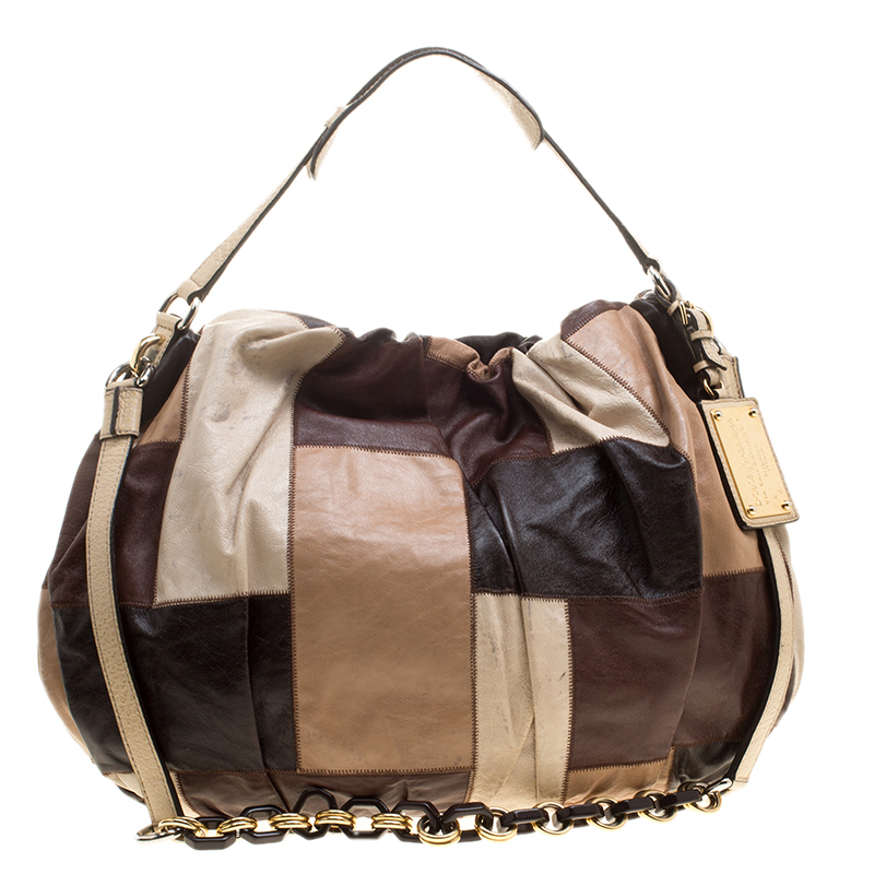 Featuring the ornate style of Dolce and Gabbana this Miss Night and Day hobo is perfect for storing all that you need for the day and hence is a must have everyday essential. The pleated leather exterior is accented with multicoloured patchwork and a dangling logo plate tag. It comes with a short handle and a long strap for your convenience. Closed with a magnetic closure the fabric lined interior comes with a zipper pocket and a cellphone pocket.