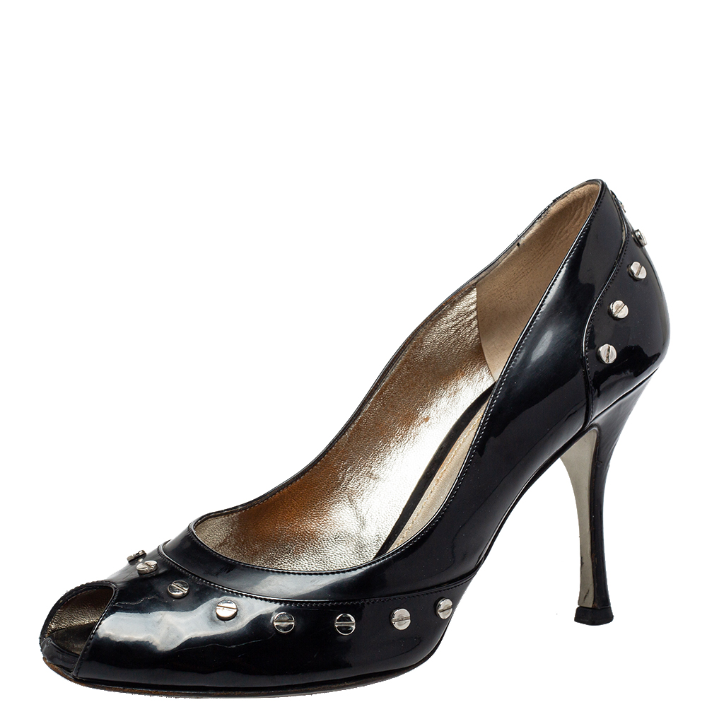 A beautifully constructed pair by Dolce and Gabbana to give you a luxurious feel. The black patent leather pumps are fashioned in a peep toe style with stud detailing on the exterior and lifted on 9.5 cm high heels. Its a classic pair of pumps youll love wearing.