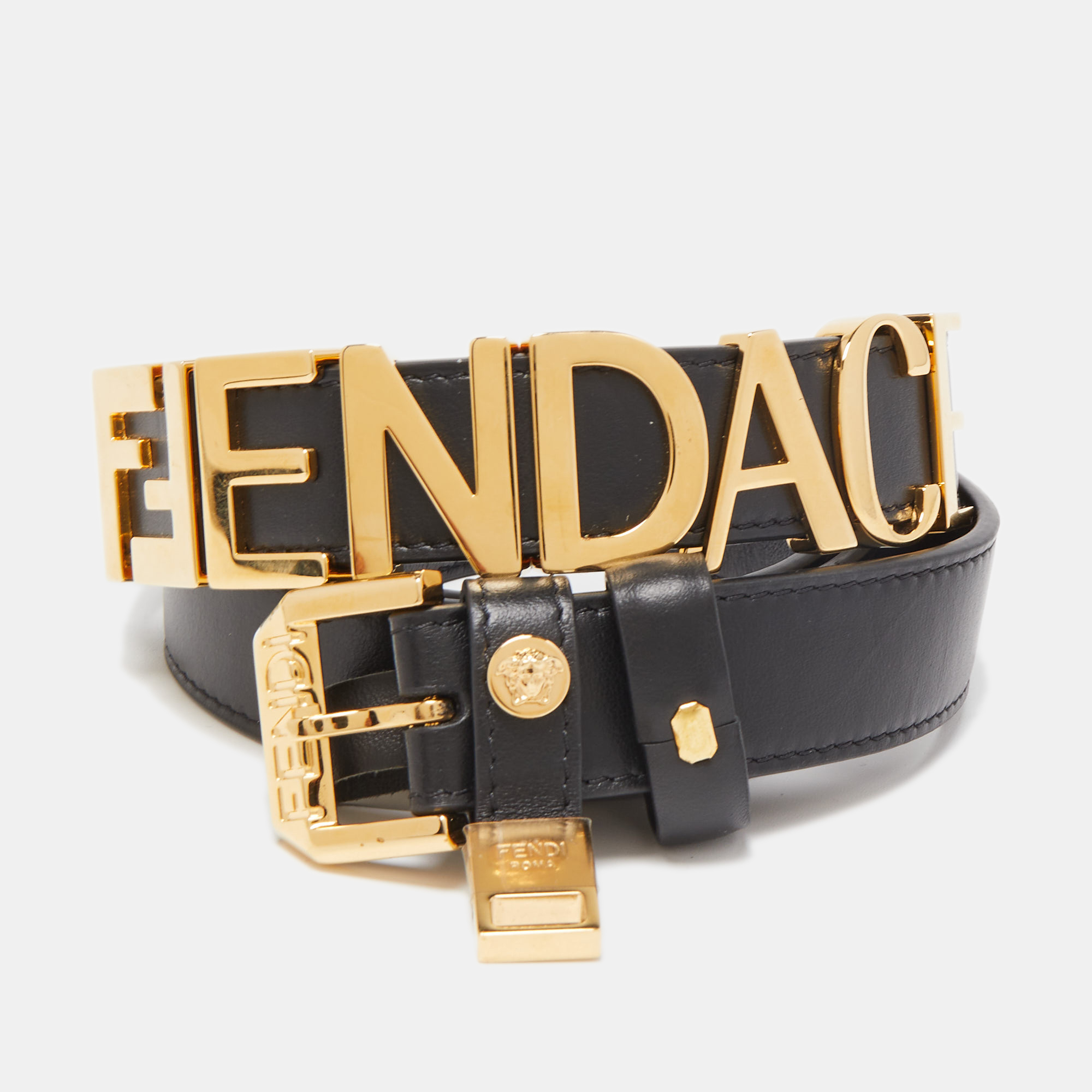 The Fendi x Versace belt is a luxurious fashion accessory that combines the iconic styles of both brands. Made from premium black leather it features a prominent buckle adorned with FENDACE logo creating a bold and stylish statement piece.