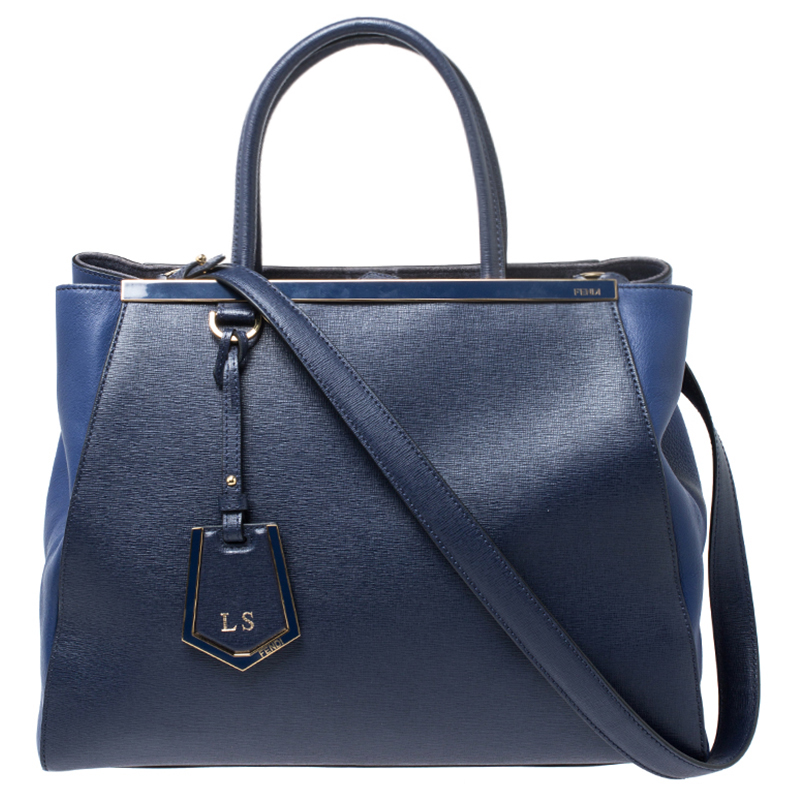 Fendis 2Jours tote is one of the most iconic designs from the label and it still continues to receive the love of women around the world. Crafted from blue Saffiano leather the bag features double rolled handles and a detachable shoulder strap. It is also equipped with a luxurious fabric and suede interior with open compartments and a zip compartment. It is finished with gold tone hardware. It will look perfect in your arms.