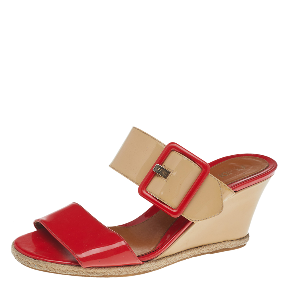 Head into summer styles by wearing chic statement designs like these sandals. These sandals from Fendi are carved using orange beige patent leather and feature gold toned implements and wedge heels. Complete your ensemble for the day by pairing these charming Fendi sandals.