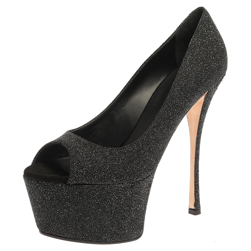 These gorgeous pumps from Giuseppe Zanotti are set on solid platforms and 16 cm high heels. They have been crafted from black glittered suede and styled with open toes. They are complete with comfortable leather lined insoles and will never fail to add infinite charm to your outfits