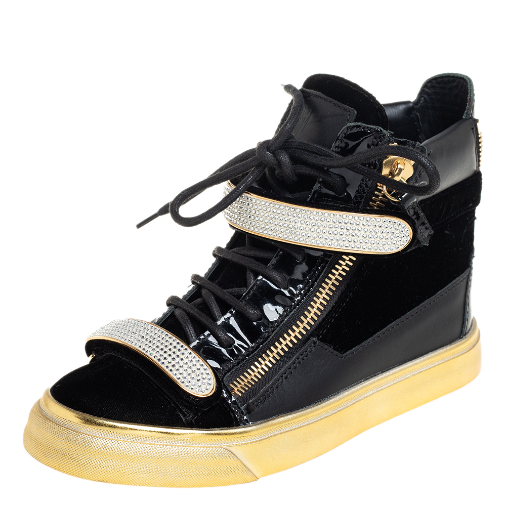 These high top sneakers from Giuseppe Zanotti are astoundingly beautiful. They have been crafted from black leather and velvet and detailed with crystal embellished velcro straps double zippers on the sides lace ups on the vamps brand logos on the tongues and single zippers on the heel counters. Comfortable leather lined insoles gold tone hardware and durable rubber soles complete this fabulous pair.