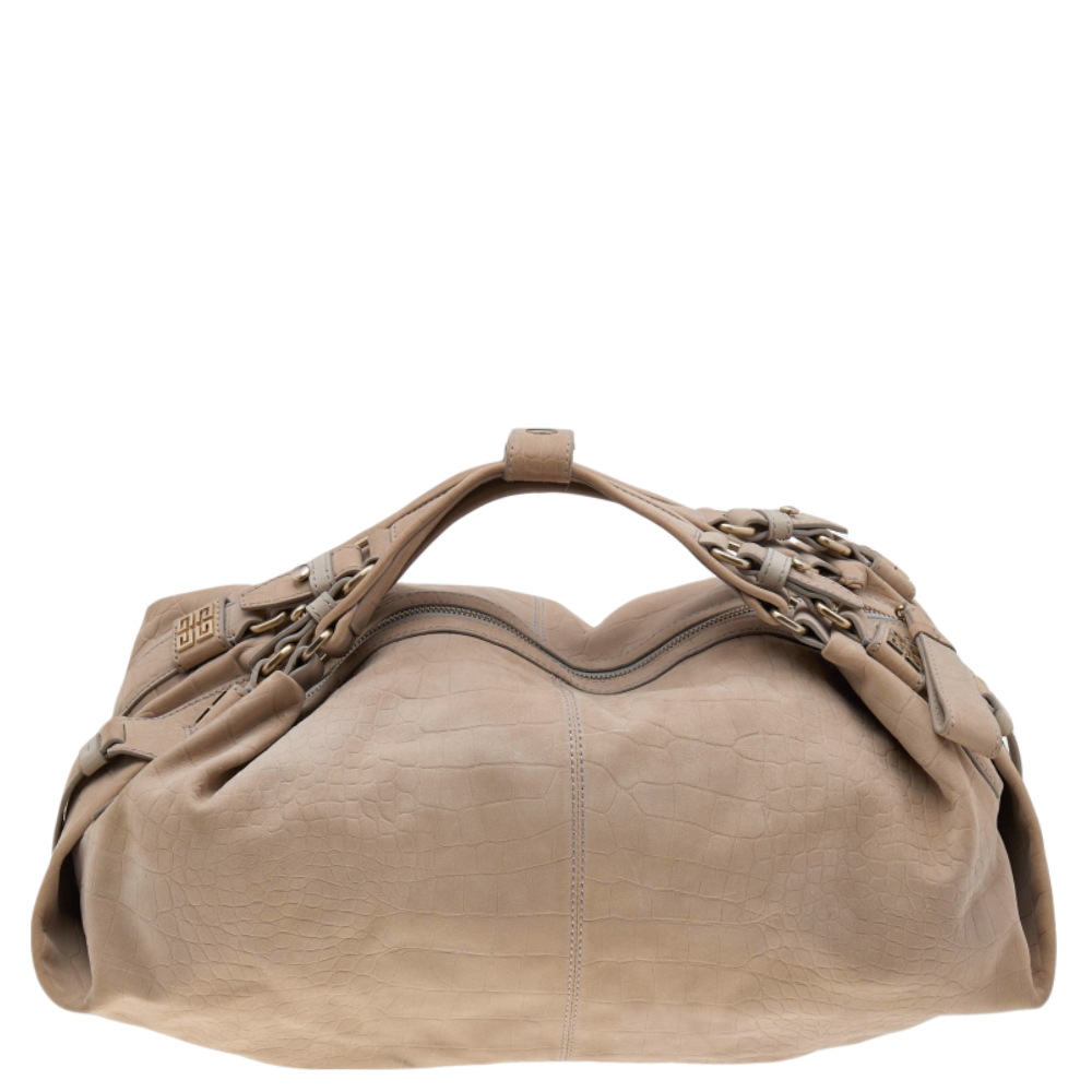 Add a luxurious touch to your collection of accessories with this Givenchy hobo. It is made from embossed leather. It comes in an understated beige hue. It is styled with short handles fabric interior and enough space for essentials. It is finished with gold tone hardware.