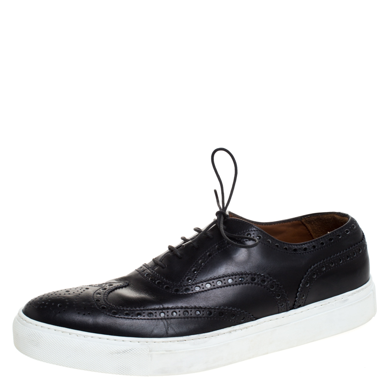 How can one not be in awe by just looking at this luxe pair from Givenchy The black leather sneakers are well crafted and they are beautified with lace ups and wingtip detailing. Comfortable insoles and contrasting white platforms complete this must have pair