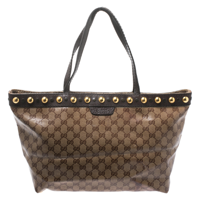Known for its high standard and fine finish this handbag from will be your companion for years to come. This gorgeous Babouska Tote from Gucci is made from beige and ebony GG Crystal canvas that is a signature of the brand. It features dual flat handles Babouska stud details in gold tone and protective feet at the bottom. The roomy interior is canvas lined and has a zip pocket.