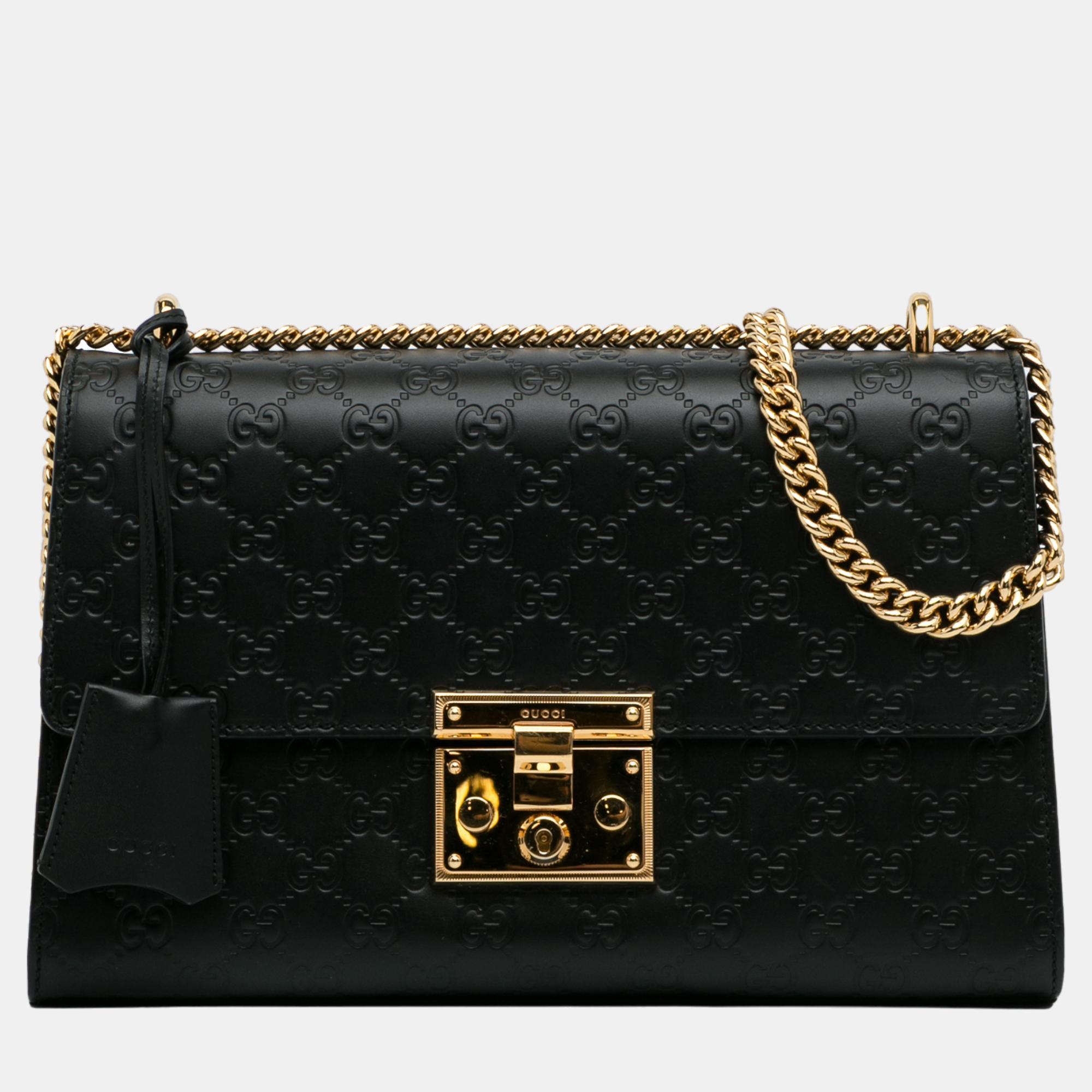 The Padlock features a leather body gold tone chain straps a top flap with push lock closure an exterior slip pocket and interior zip and slip pockets.