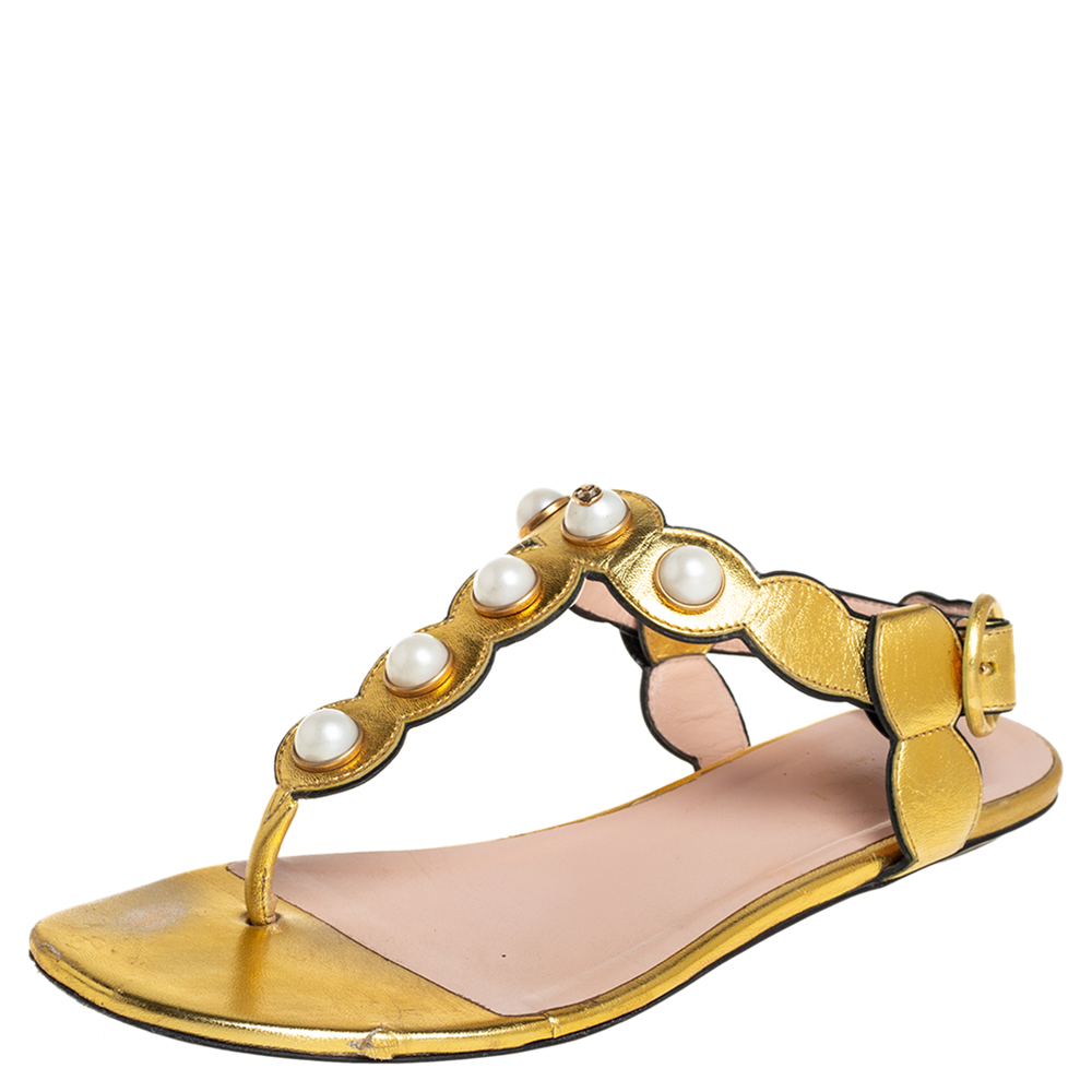 Perfect for channeling an air of elegance these sandals from Gucci are worth investing in. The gold sandals are crafted from leather and feature a T strap design with pearls buckled ankle straps comfortable leather lined insoles and gold tone hardware.