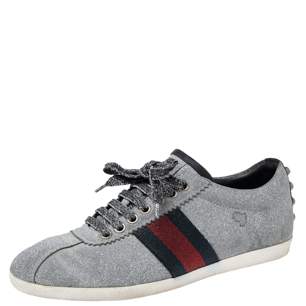 Stacked with signature details this Gucci pair is rendered in silver glitter and is designed in a low cut style with lace up vamps studs on the counters and Web trim on the sides. These shoes can be easily coordinated with your casuals.