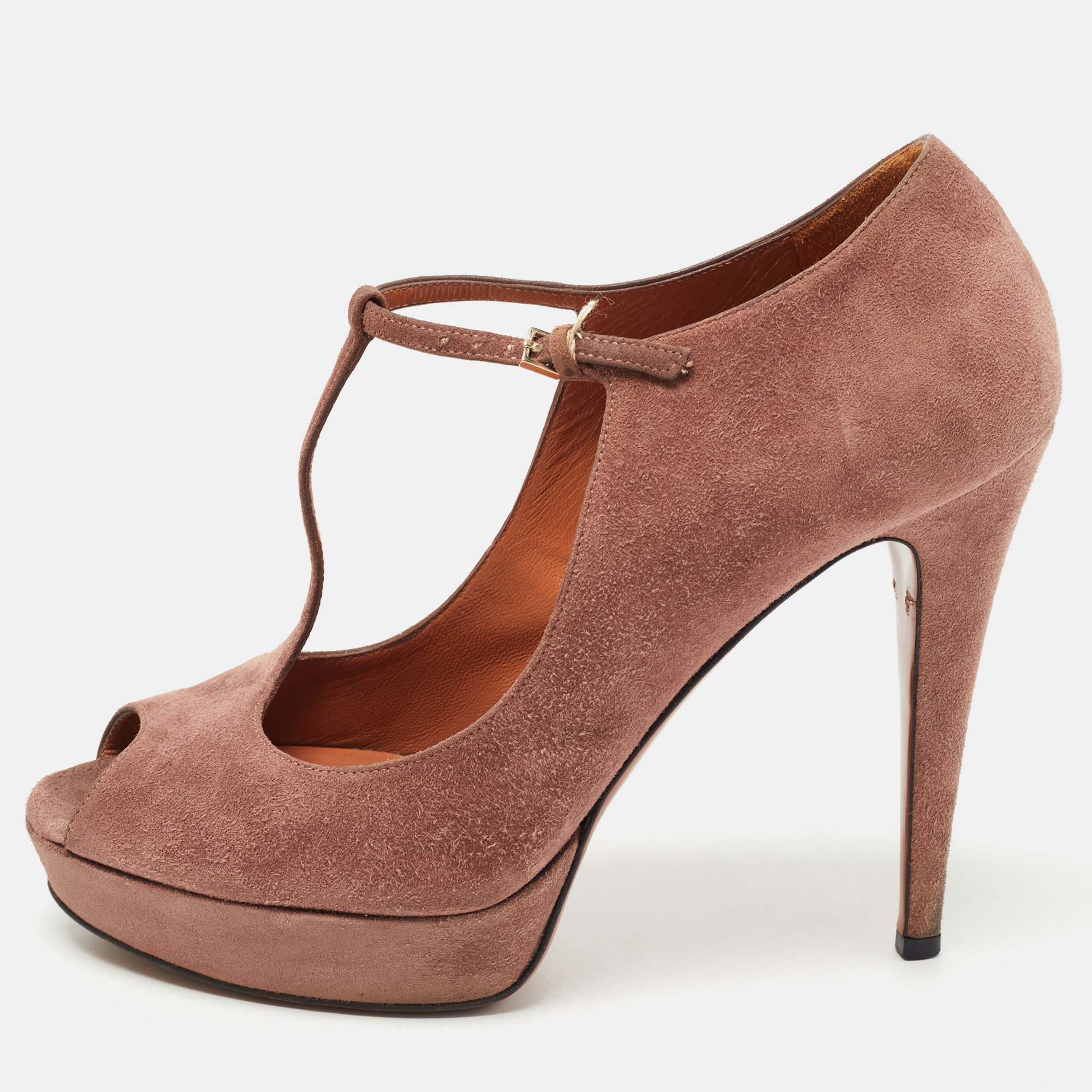 Flaunt elegance with this pair of pumps from Gucci. They are creatively designed using pink suede on the exterior. They showcase peep toes platforms a T strap and slim heels. Elevate your style by wearing these amazing sandals.