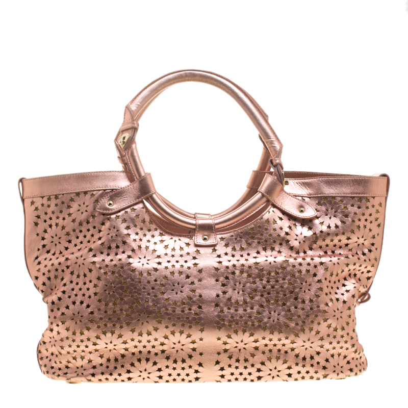 The metallic rose gold shade will stand out every time you swing this beauty. Get your hands on this beautiful leather tote to nail a picture perfect look. It is from Jimmy Choo and it is designed with laser cuts two top handles and a spacious suede interior.