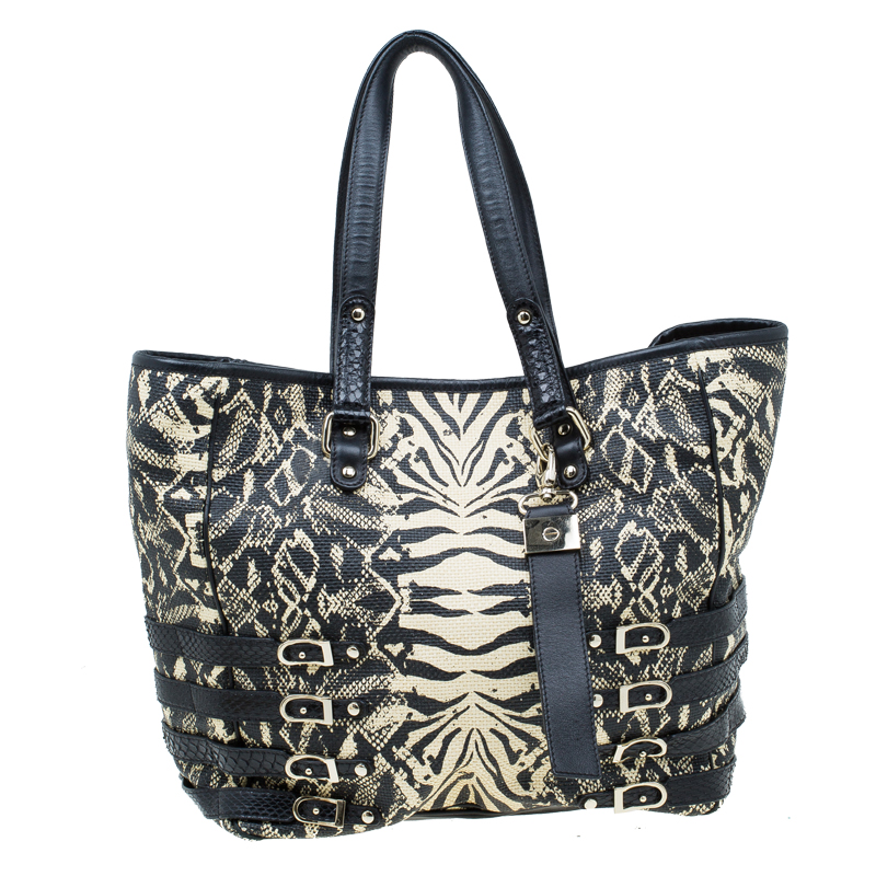 Jimmy Choo is all set to impress you with its new collection of Babeth shopper tote that a lady will never fail to flaunt. Crafted from printed raffia it is adorned with attractive belted straps and features two top handles. This tote is accentuated with gold tone stud details and four protective feet. It comes with a suede lined interior that houses open pockets and a zipped pocket and carries brand labeling.