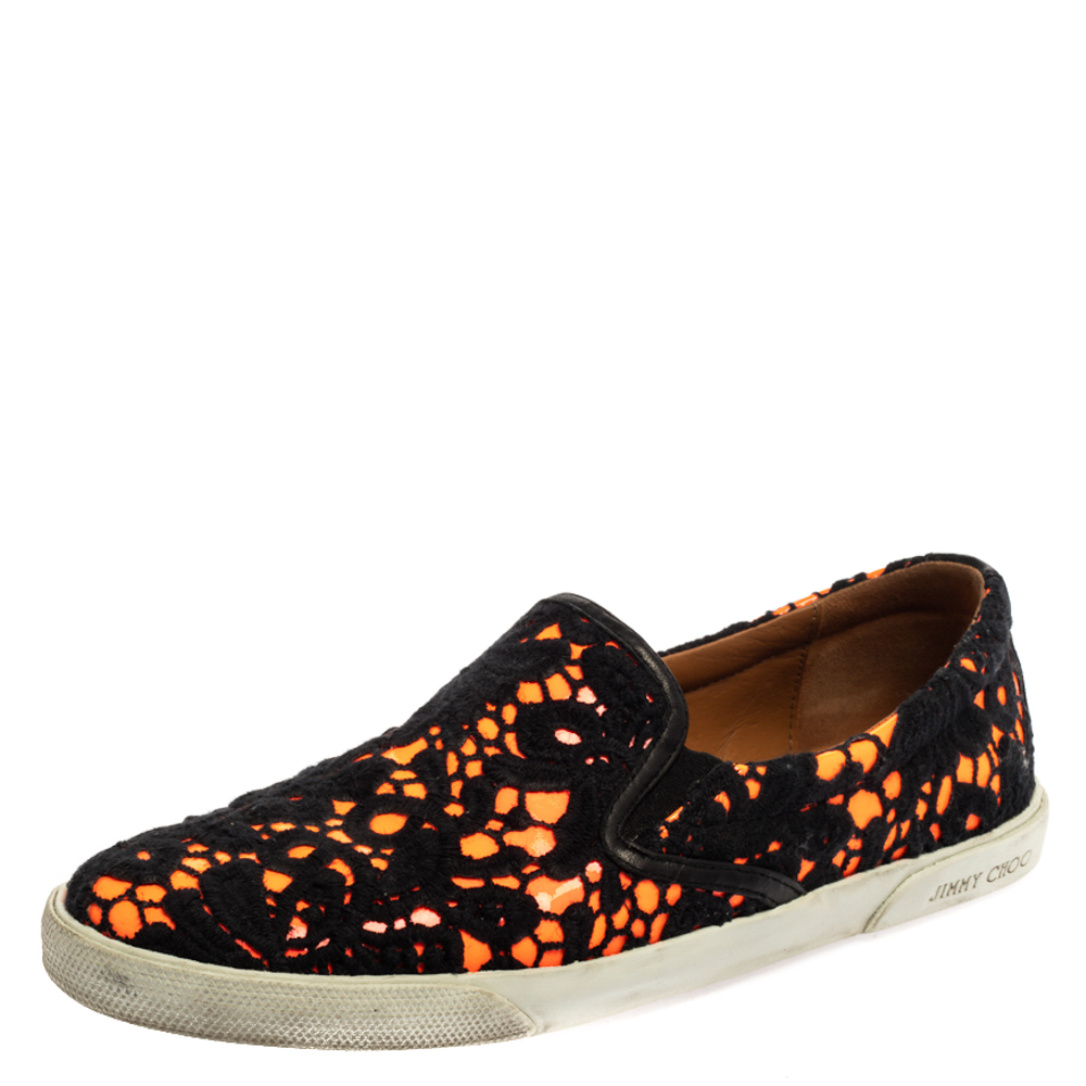 Ones wardrobe is incomplete without a good pair of sneakers and what better than these Jimmy Choo ones These black and neon orange slip on sneakers have been crafted from lace and patent leather. They are styled with round toes and durable rubber soles. This pair will look great with casuals.