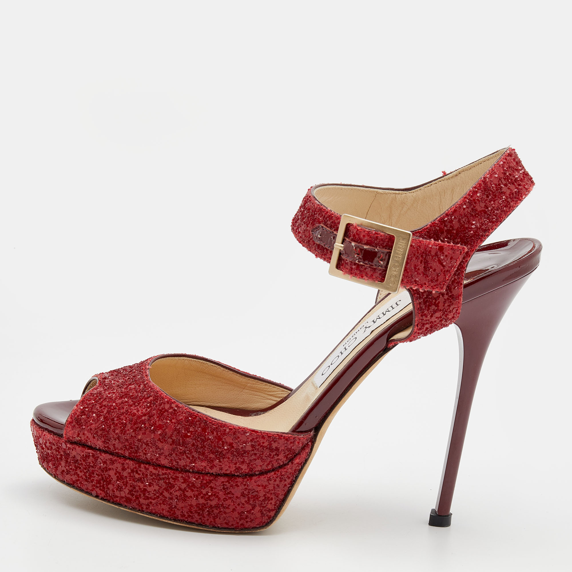Feel luxuriously fashionable in these Jimmy Choo platform sandals. They have been crafted from ravishing red glitter and are finished with gold tone buckles slender 12.5 cm heels and leather lined insoles. Add them to your closet today