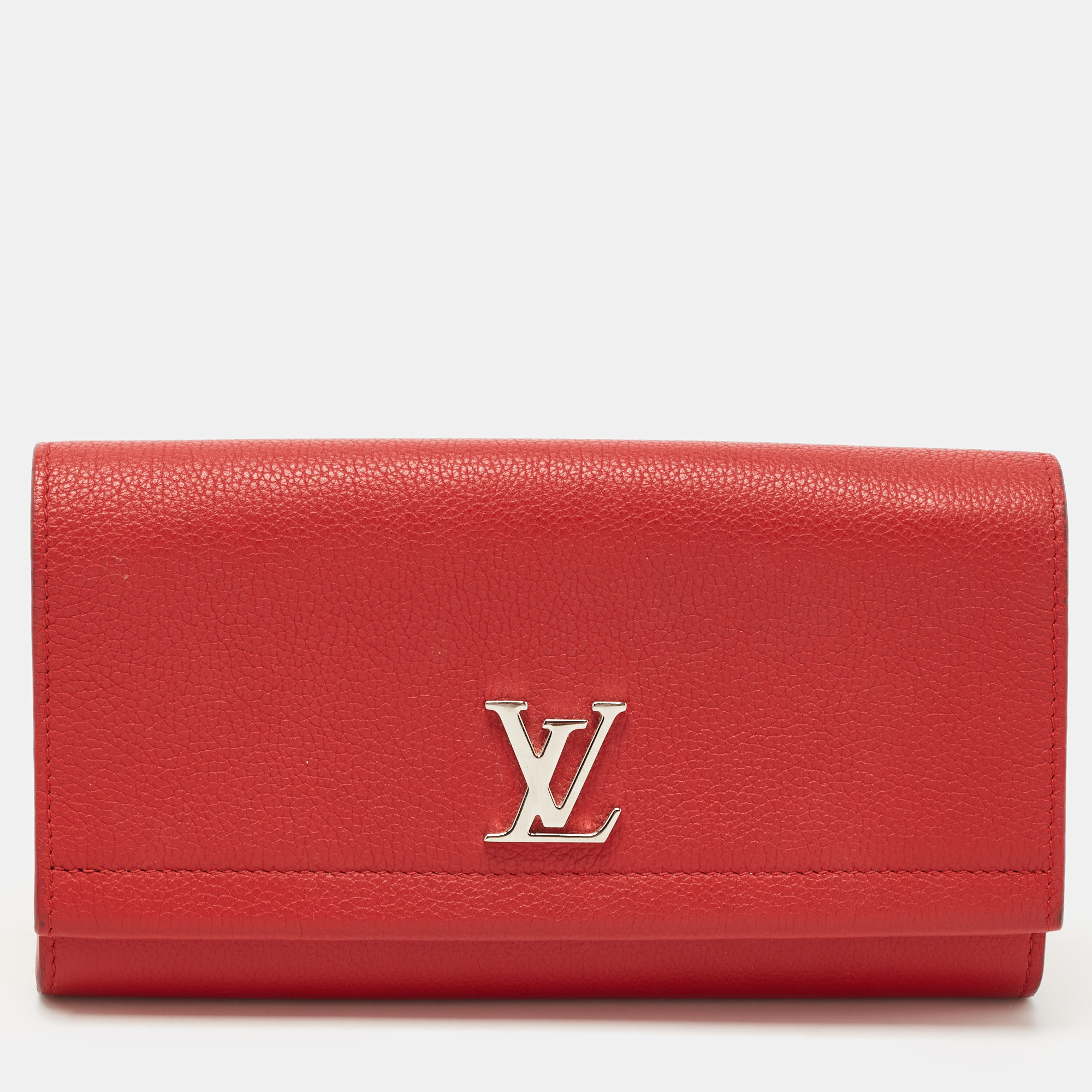 This luxurious Lock Me ll wallet by Louis Vuitton will be a joy to carry around. Made from red leather the flap features the signature LV logo in silver tone metal. It opens to reveal a compartmentalized interior.
