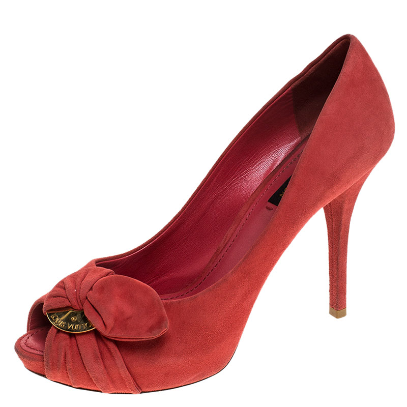 From Louis Vuittons Spring 2011 collection these 'Catania' peep toe pumps are crafted in red suede and are adorned with ruched bow detailing and gold tone LV engraved plaques. These beauties sit on 11 cm heels to lend you an elegant height.