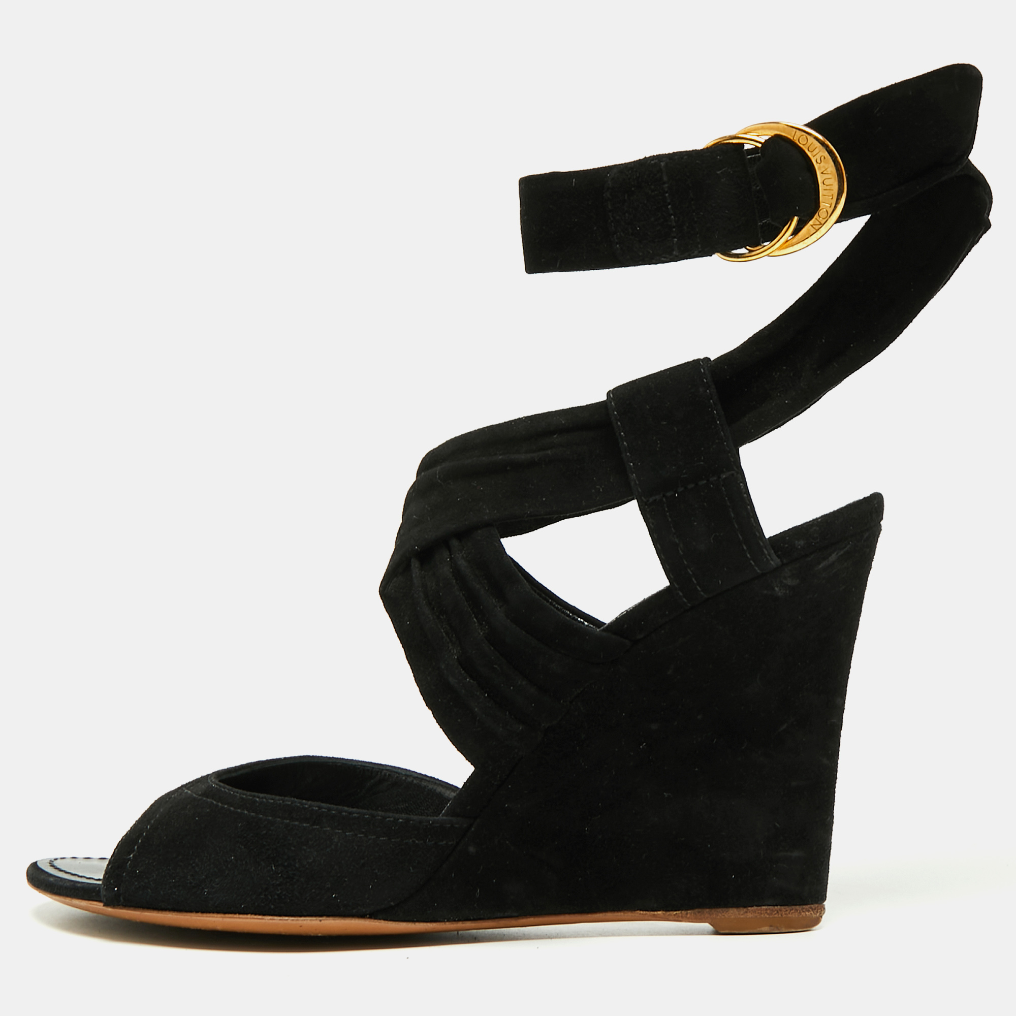 These sandals from Louis Vuitton are beautiful in every way. They are created using black suede on the exterior and show open toes gold toned hardware and an ankle wrap feature. They are elevated on wedge heels.