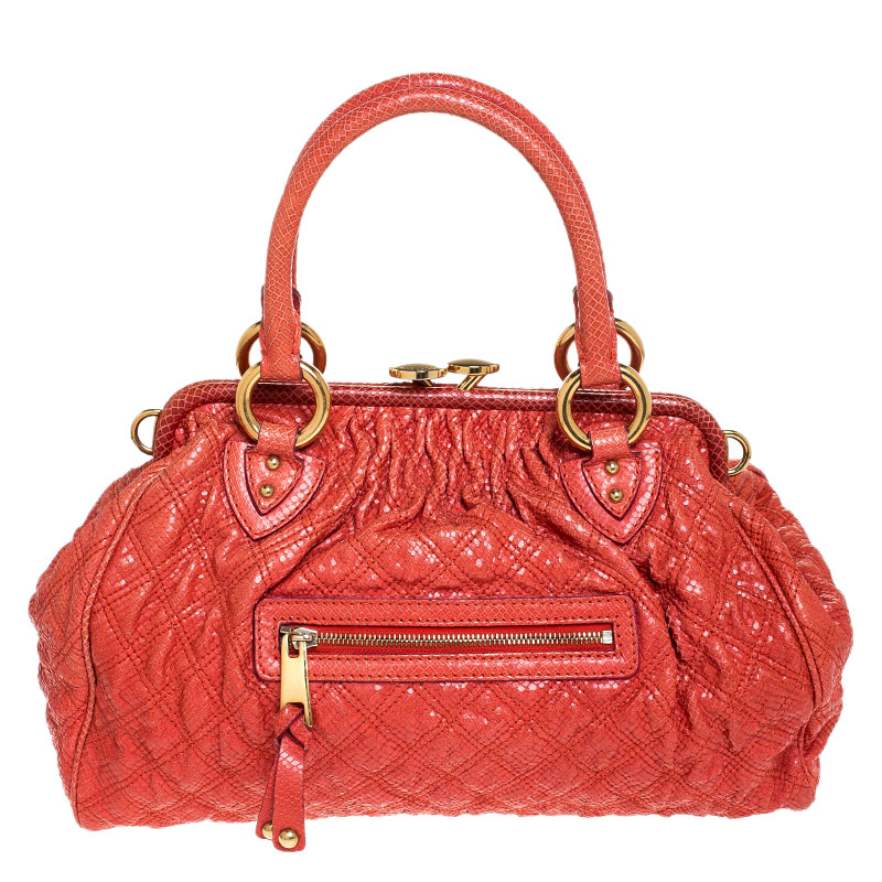This Marc Jacobs design has an orange quilted exterior crafted from snakeskin embossed leather and enhanced with gold tone hardware. This elegant Stam bag features a kiss lock top closure that opens to a fabric interior dual top handles and a removable chain that converts this piece between shoulder and hand styles easily. Swing this beauty wherever you go and make heads turn