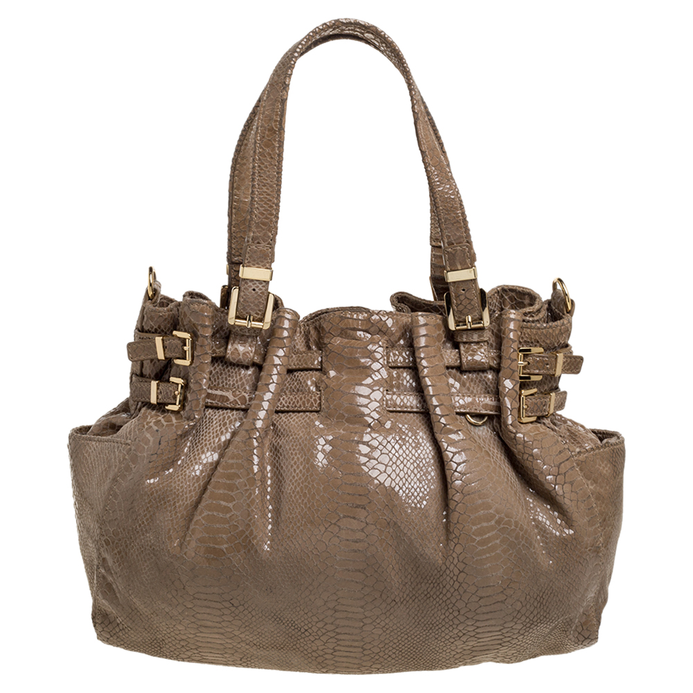 This bag from MICHAEL Michael Kors will be your indispensable companion. A fresh take on femininity this bag is designed from python effect patent leather in a beige hue. It has buckle details dual handles and a roomy interior. This shoulder bag will complement most of your attires.