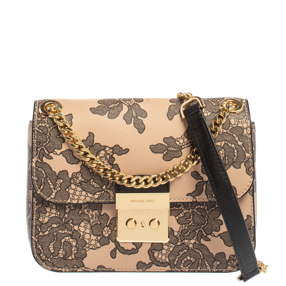 Fall in love with this Sloan bag from Michael Kors. Crafted from pink and black leather the bag is adorned with a lovely floral print all over and flaunts a gold tone lock on the front. It has a spacious nylon lined interior that has a zip pocket. This beauty is complete with a chain link and leather shoulder strap.