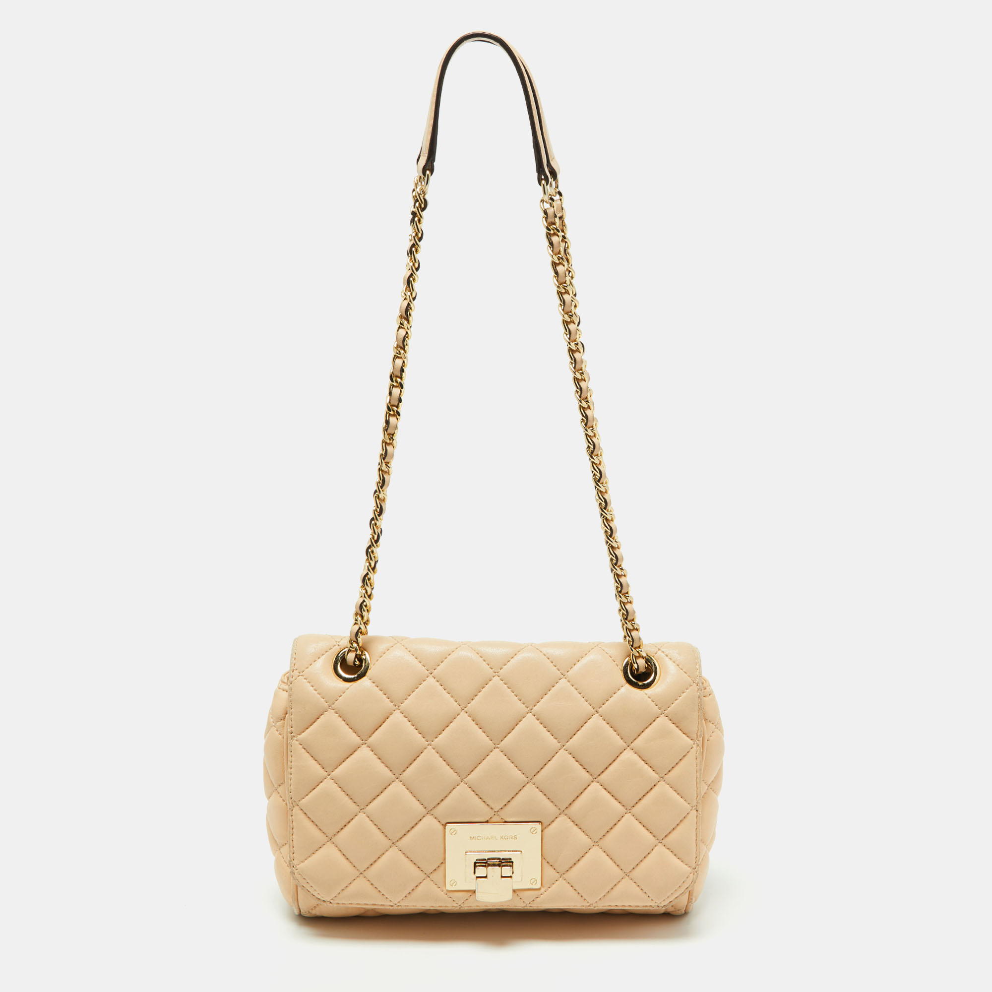 With the festivities around the corner pamper yourself with this chic shoulder bag from the house of Michael Kors. It has been designed from a beige quilted leather body with a flap style secured with a gold tone buckle closure. It comes fitted with chain shoulder strap fitted with a leather shoulder pad. This bag is ideally proportioned to hold your evening essentials in great style.