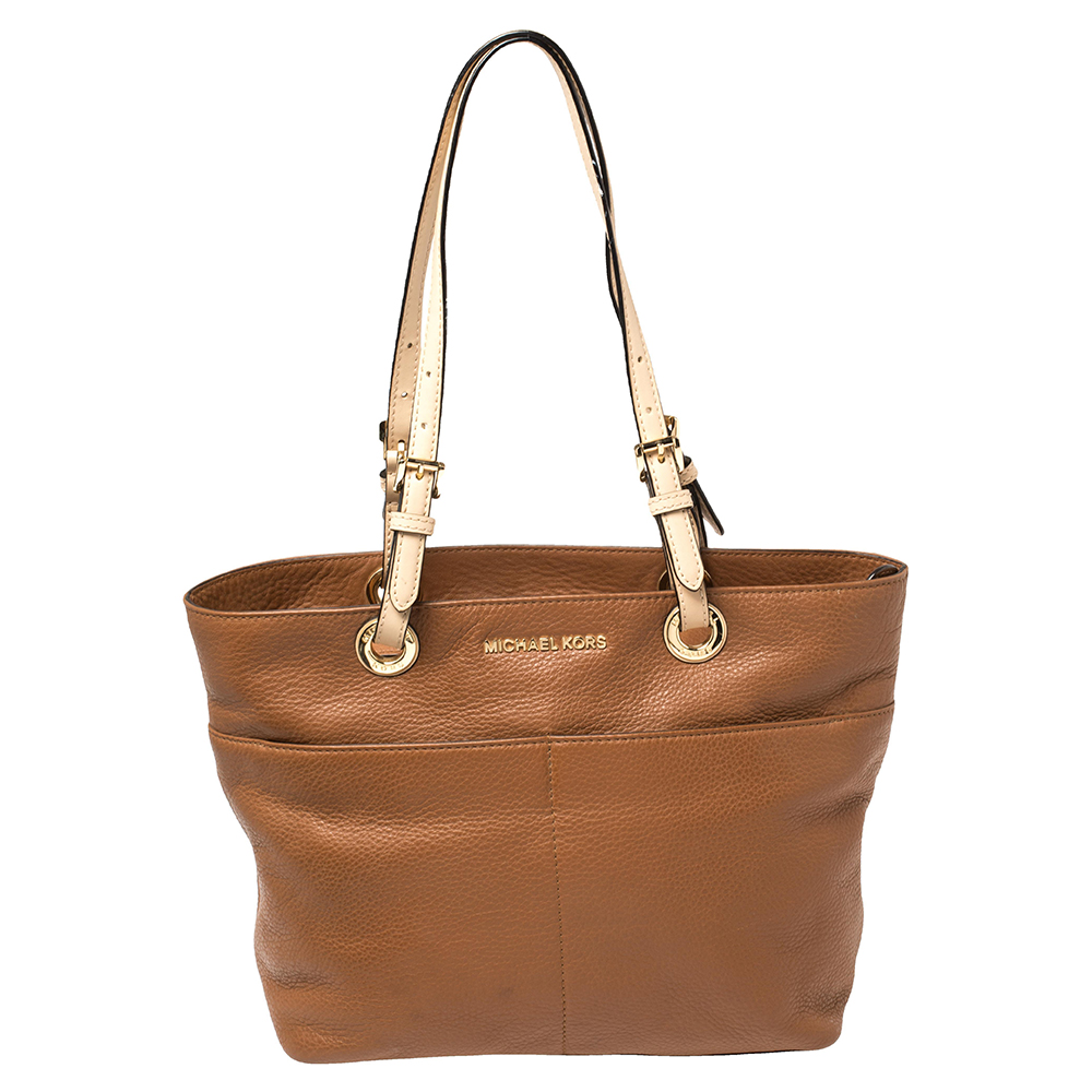 Pair this MICHAEL Michael Kors Bedford tote with any outfit and look fashionable. The bag is crafted from leather and features dual handles with buckle details and the brand logo on the front. The spacious nylon lined interior will dutifully hold all your daily essentials. Grab it right away