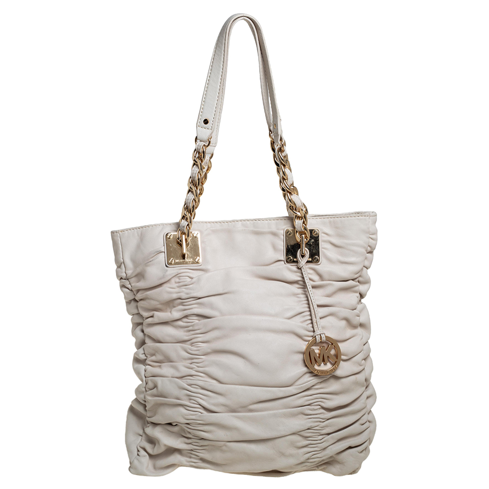 Timelessly elegant and stylish MICHAEL Michael Korss collections capture the effortless nonchalant finesse of the modern woman. Crafted from leather in a white hue this chic tote features pleated details all over the exterior a spacious interior with additional pockets inside. The sleek understated silhouette is punctuated with gold tone hardware and an MK medallion.