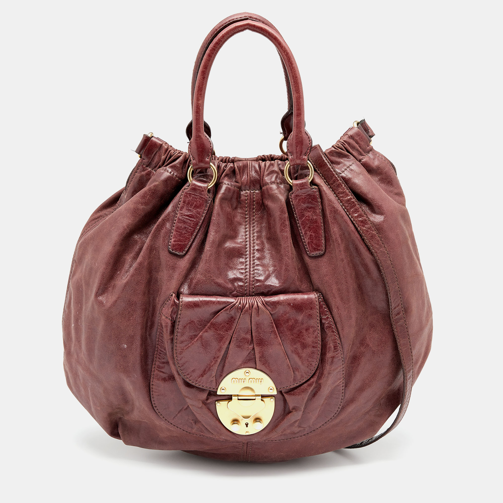 The front external pocket and dual carrying options enhance the practical utility of this Miu Miu hobo. Made from leather it gets a luxe update with the brand signature in gold tone on the front. The satin lined interior has more than enough space to perfectly house your daily essentials.