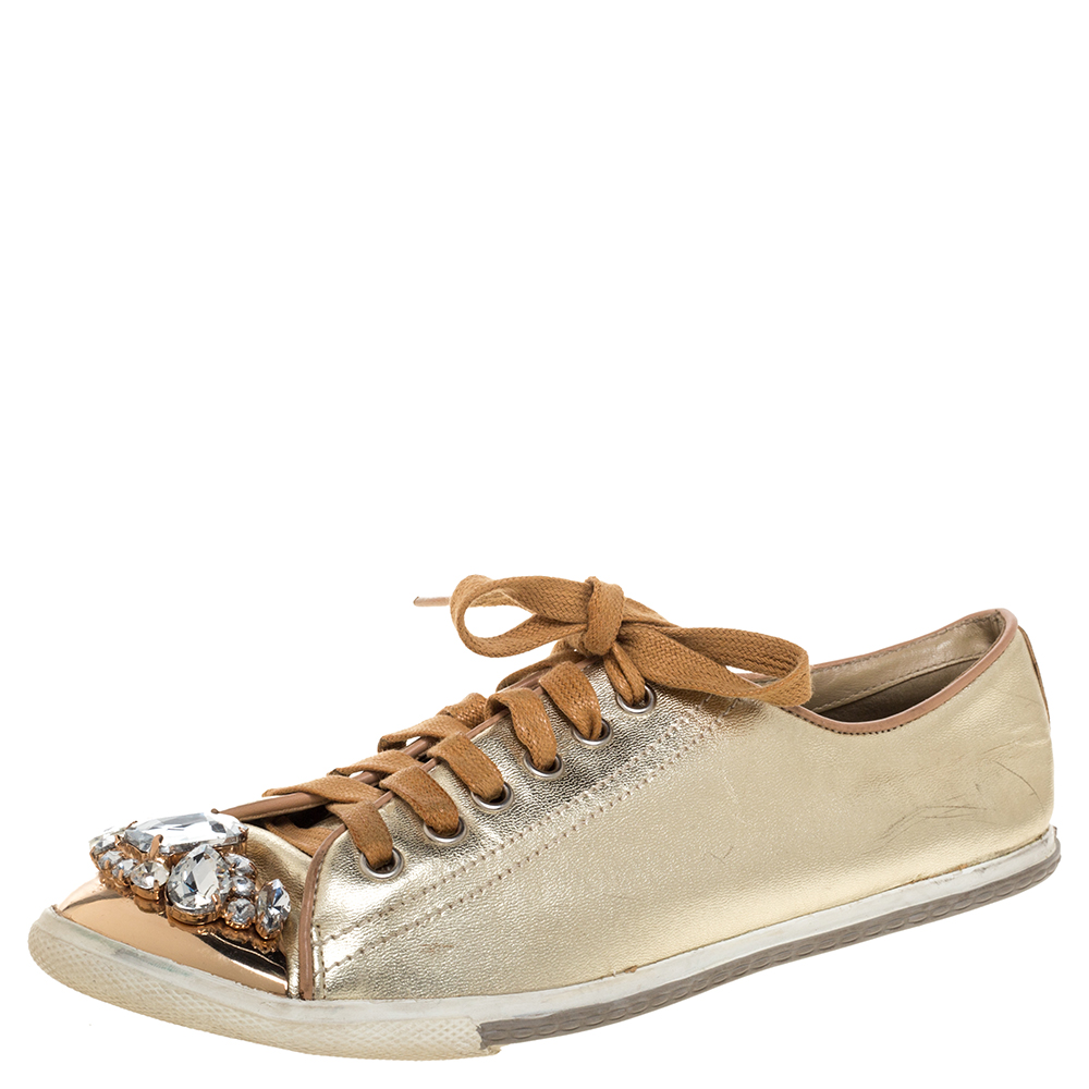 Who says sneakers cannot have a touch of sparkle? These Miu Miu sneakers are brilliantly crafted from gold hued leather and detailed with lace ups and crystals. They are set on comfortable rubber soles and makes a great pair to dresses and skirts alike.