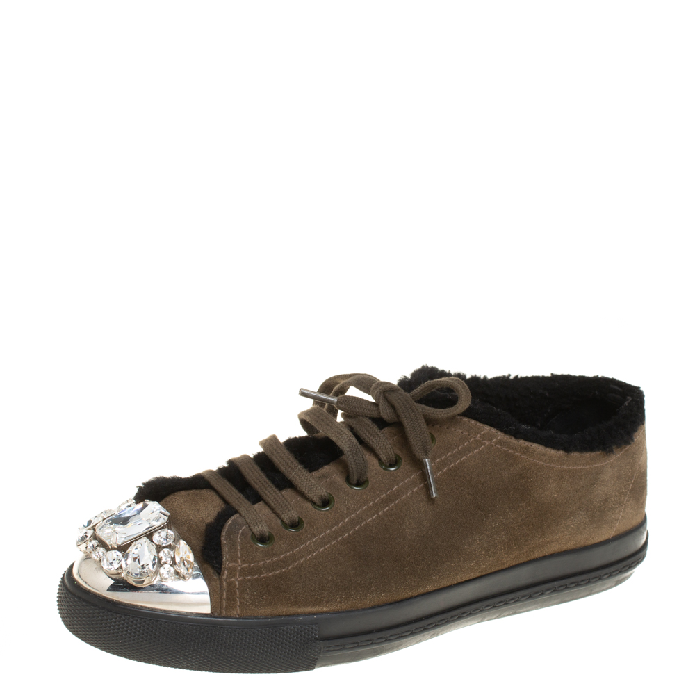 A signature Miu Miu style these low top sneakers for women are crafted in suede lined with shearing on the insoles and detailed with crystals on the cap toes. They are secured with lace ups and set on durable rubber soles.