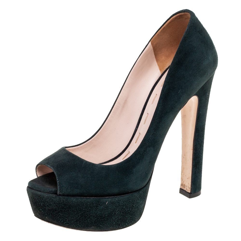 If you like to move in style then this pair of Miu Miu pumps is an ideal choice for you. These dark green shoes have been rendered from suede and feature peep toes platforms and leather lined insoles. Balanced on 14 cm heels theyll enhance any outfit.
