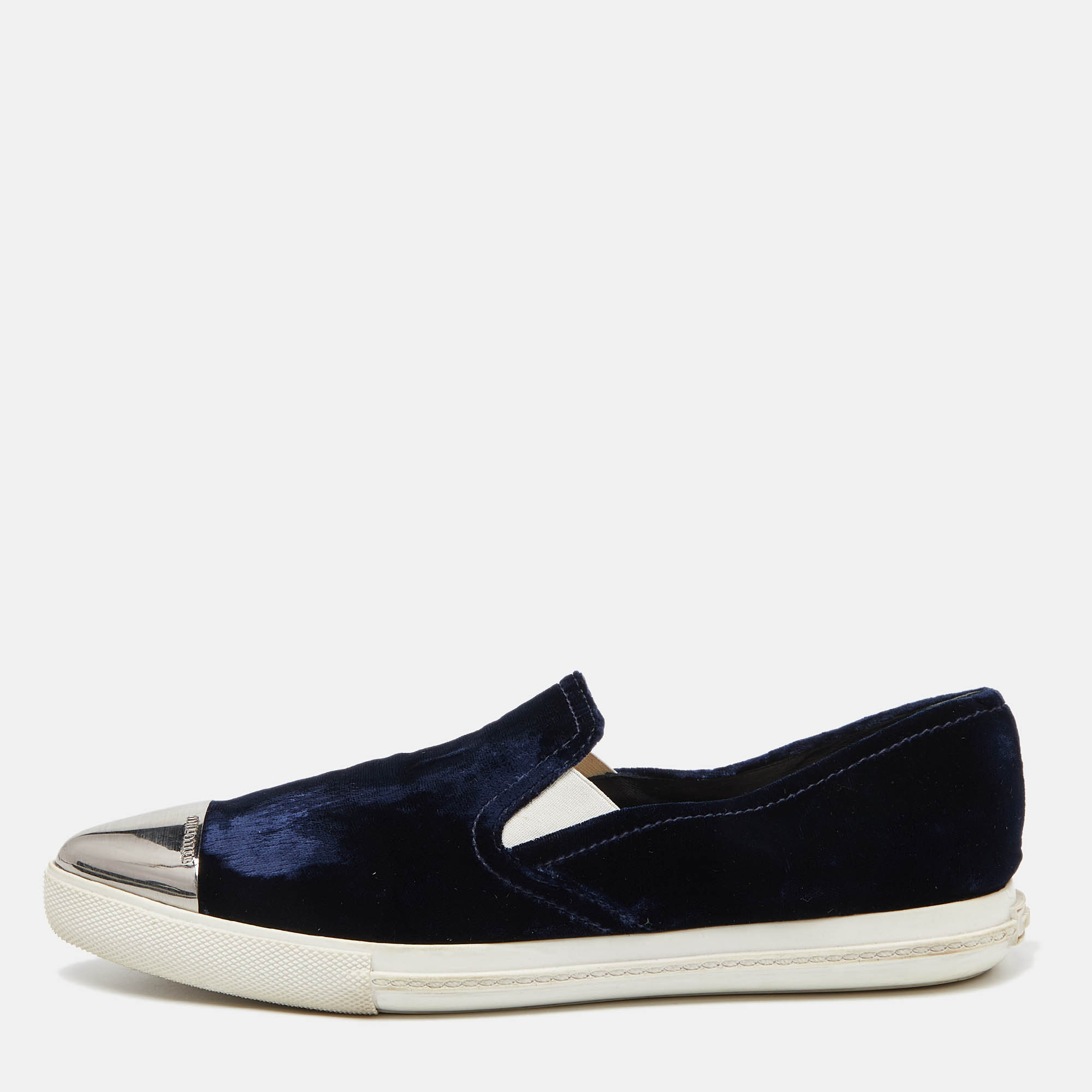 These slip on sneakers from Miu Miu are amazingly stylish The blue sneakers have been crafted from velvet and feature contrasting pointed cap toes. They come equipped with comfortable leather lined insoles and tough rubber soles.
