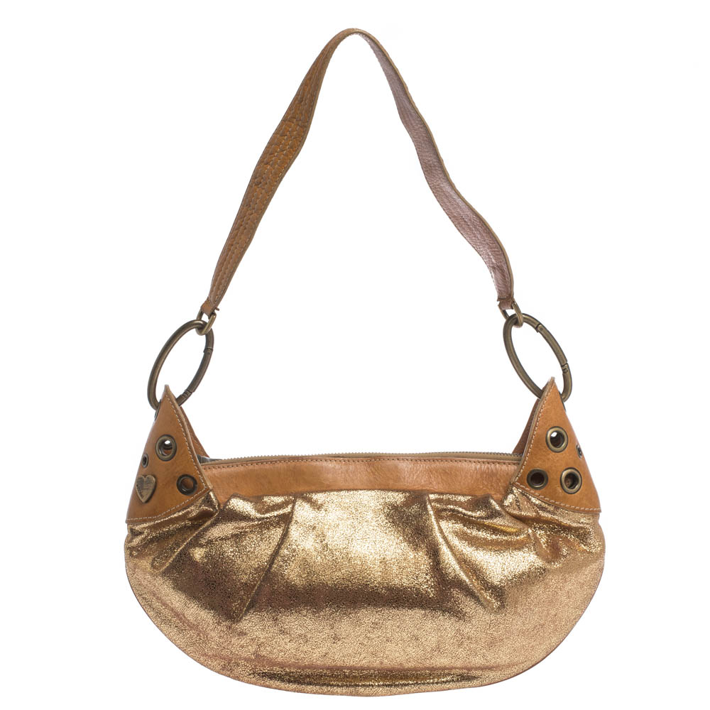 This shoulder bag from Moschino is crafted in Italy from leather and comes in a stunning gold shade. It has an iridescent sheen on the exterior. The smooth trim on the top opens to reveal a satin lined interior. It is held by a single shoulder strap. The bag is completed with gold tone hardware.