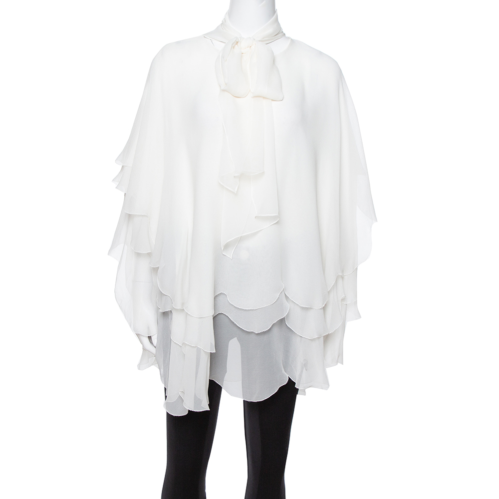 Oscar de la Rentas blouse perfectly complements your style with respect to comfort and style. This off white blouse is so pretty that youll look like a fashionista every time you slip into it. Flaunting an amazing layered silhouette along with a necktie this blouse is complete with hook fastening.
