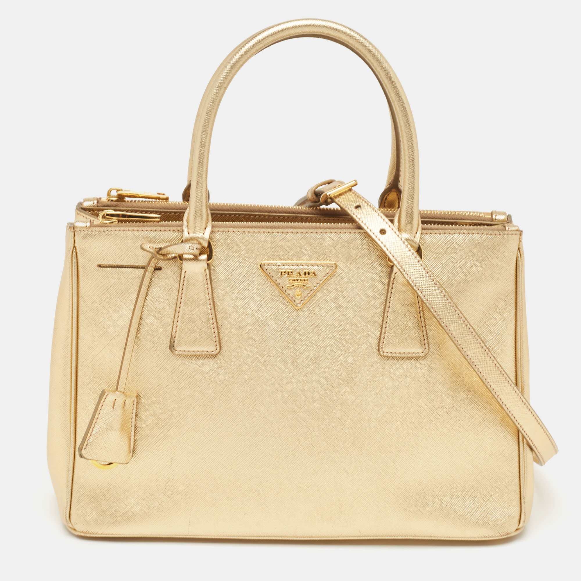 This Prada gold tote is an example of the brands fine designs that are skillfully crafted to project a classic charm. It is a functional creation with an elevating appeal.