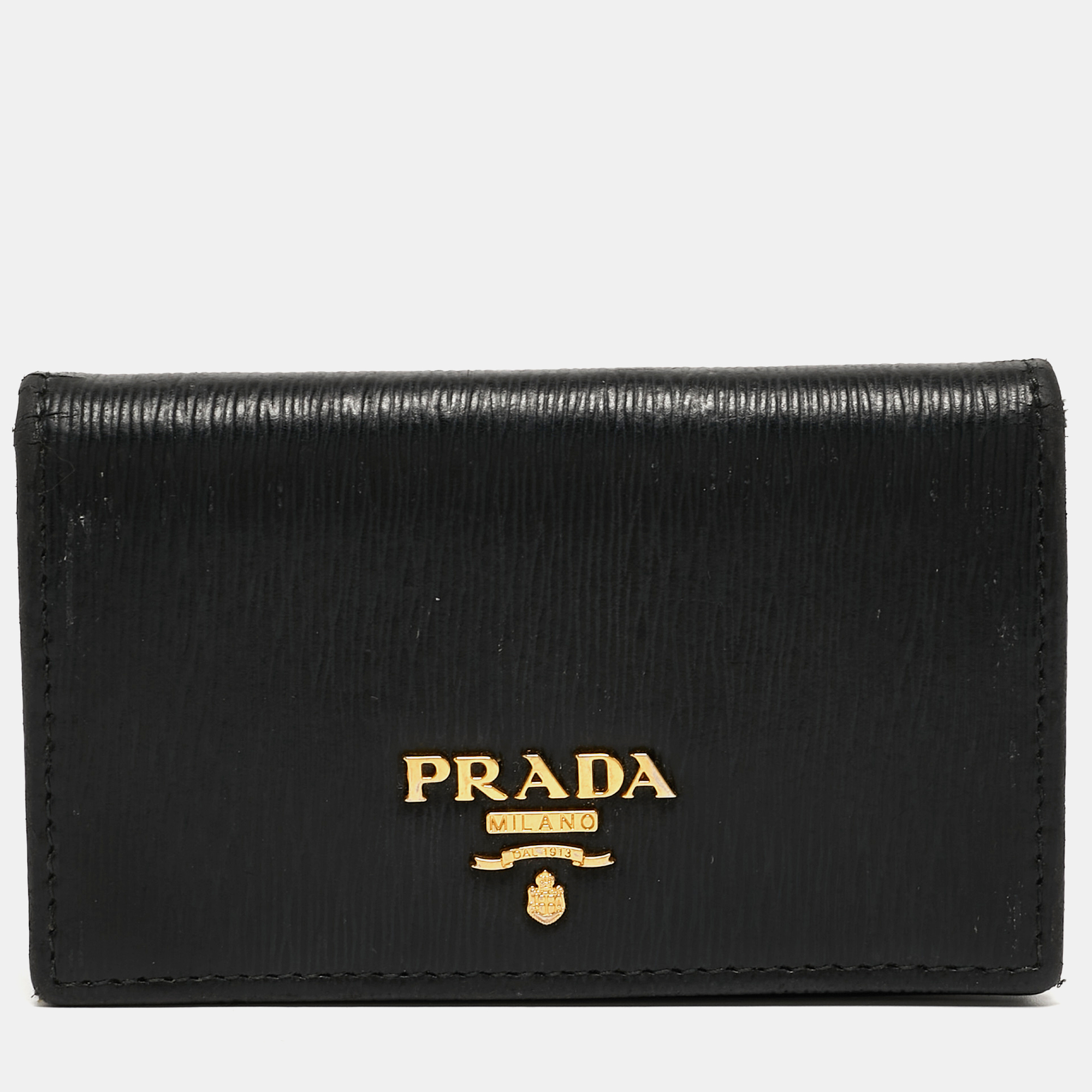 This card case from Prada will help you store your valuables securely. It is made from black Saffiano leather and flaunts a logo lettering on the front. This card case has gold tone hardware and opens to a leather nylon interior.