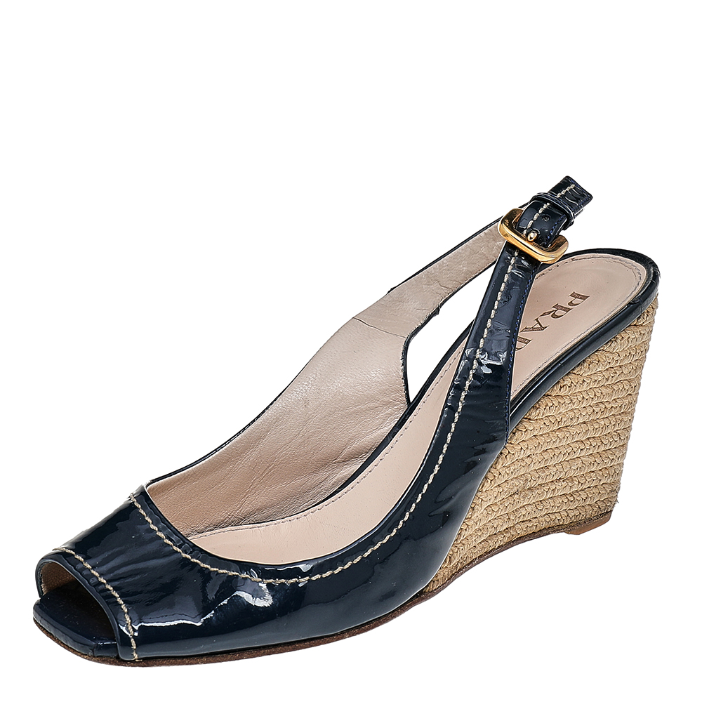 Update your designer collection by adding these sandals from Prada. They are creatively made using navy blue patent leather on the exterior with gold toned hardware contrast stitch detailing and espadrilles added to their structure. Additionally they feature peep toes and a slingback.