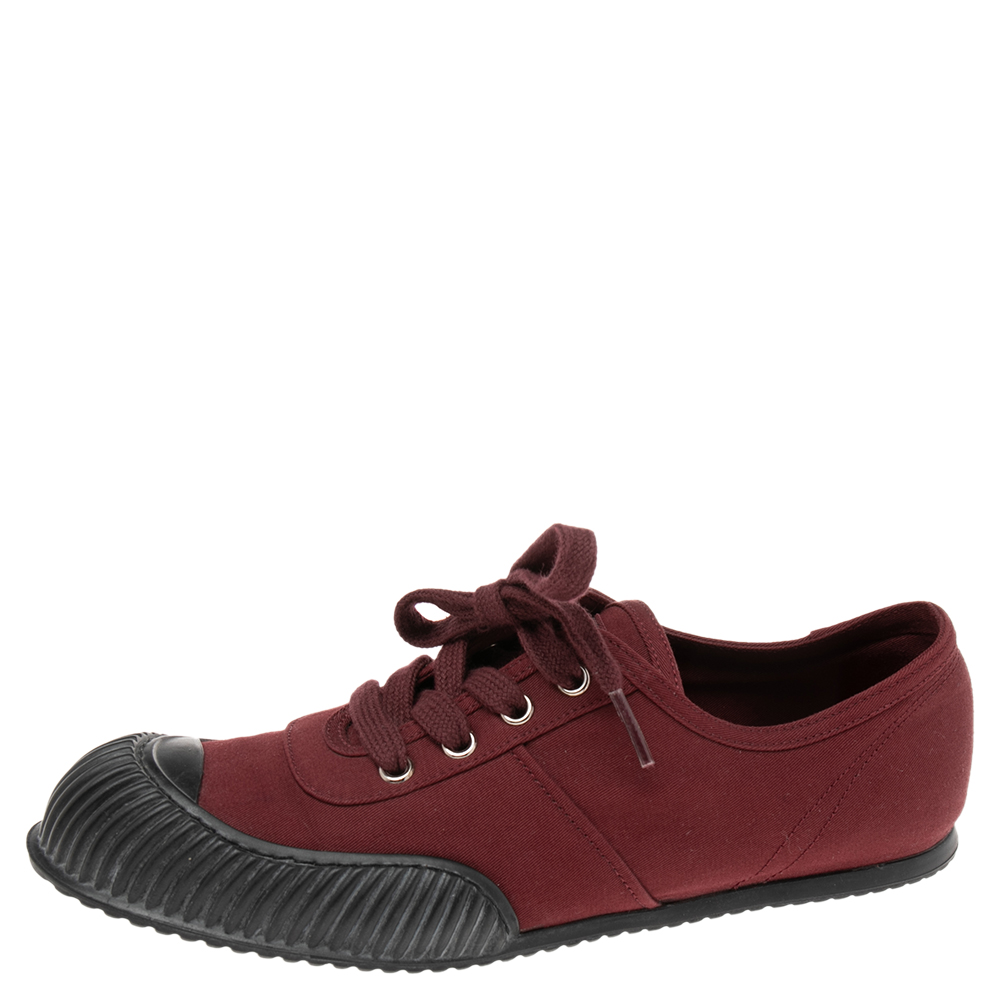 Coming in a classic low top silhouette these Prada sneakers are a seamless combination of luxury comfort and style. They are made from canvas in the burgundy shade. These sneakers are designed with logo details laced up vamps and comfortable insoles.