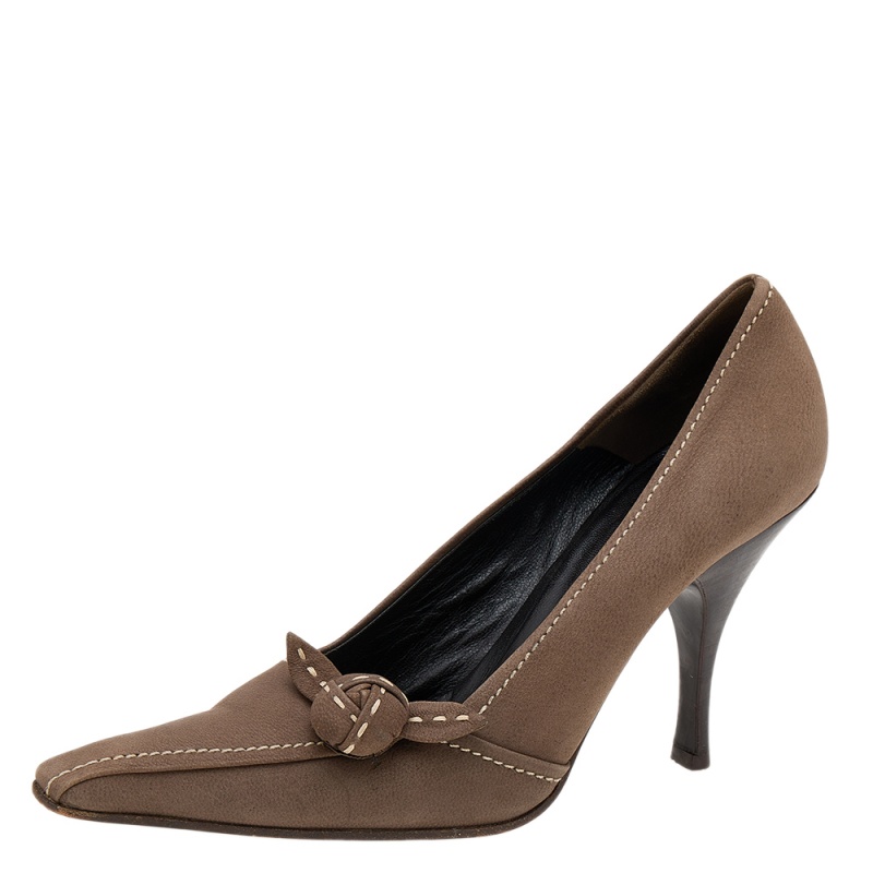 How classy are these pumps from the House of Prada They are designed using khaki brown leather which is augmented with stitch detailing and a knot on the front. They showcase a slip on feature and slim heels. Make a fashion statement as you walk in these pumps.