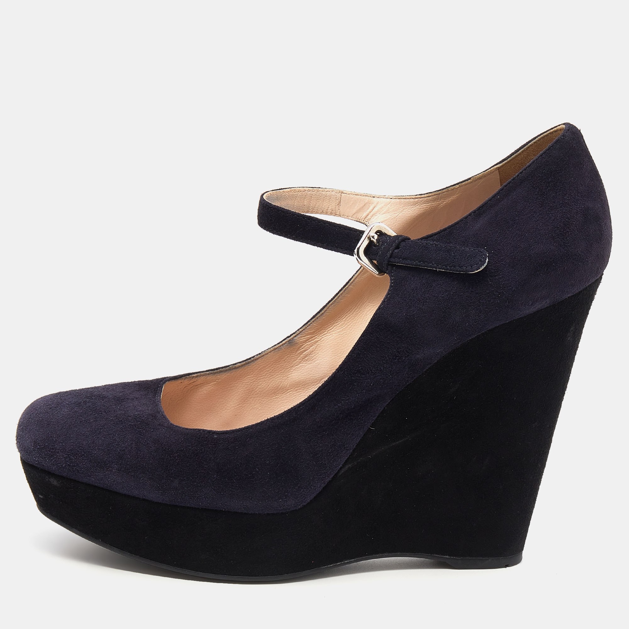 Work your magic while donning these beautiful pumps crafted from dark purple suede. Perfect for day to night looks this pair of Prada pumps matches well with flowy pleated dresses. It is complete with buckled closures and 11.5 cm wedge heels.