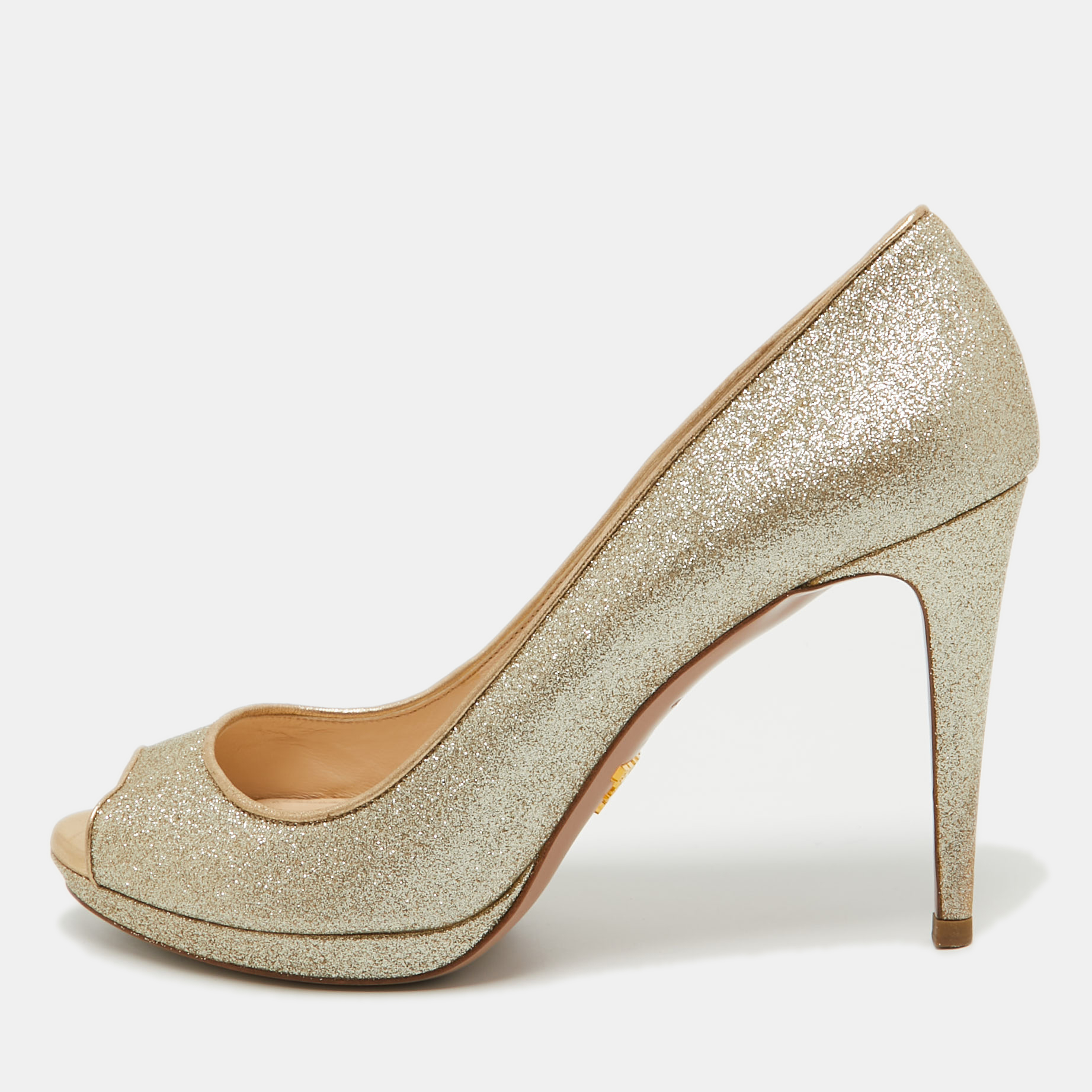Beautifully designed this pair of pumps features a beautiful metallic gold glitter body. They are designed by Prada to make you shine. The pumps feature peep toes leather insoles and 10.5cm heels supported by platforms. Grab these classic pumps now