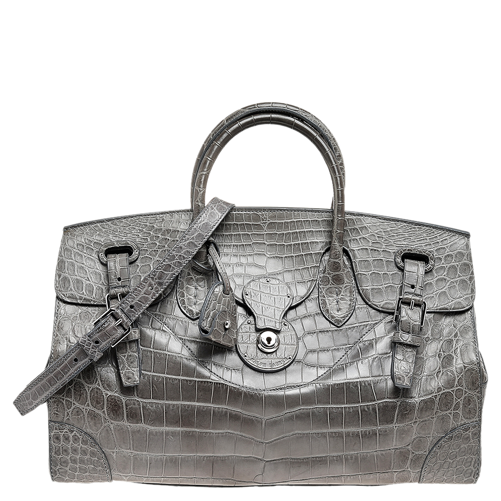 This Ralph Lauren Ricky bag is simply breathtaking. Meticulously crafted from alligator leather the bag delights not only with its appeal but its structure as well. It is held by two top handles detailed with silver tone hardware and equipped with a spacious leather interior. The fabulous shape the enticing color and the impeccable style of creation effortlessly add to the marvel of this royal piece.
